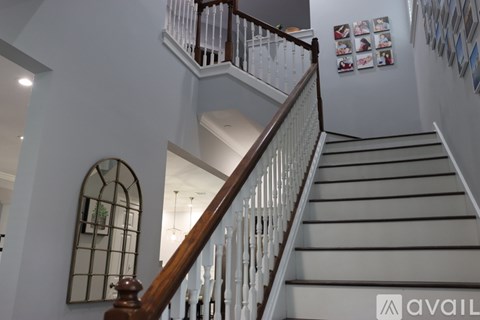 A staircase with a wooden handrail and white balusters.