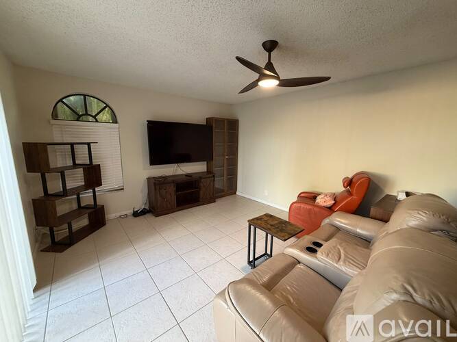 A living room with a television, a couch, and a coffee table.