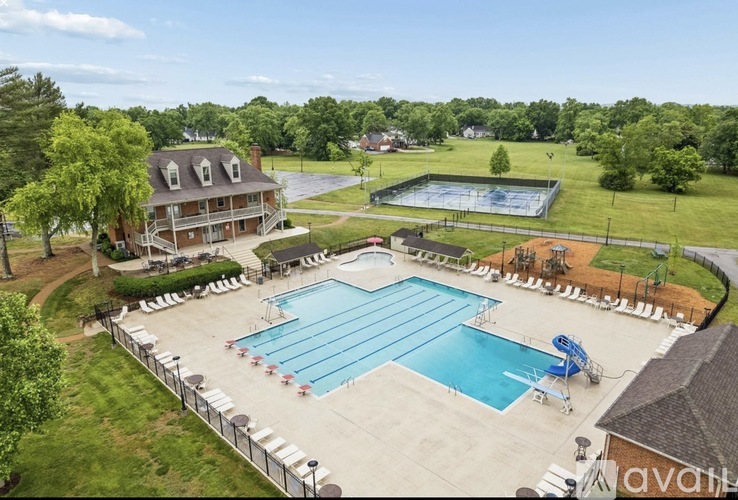 An outdoor swimming pool surrounded by a metal fence.