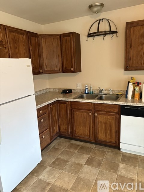 A kitchen with brown cabinets and a white refrigerator.