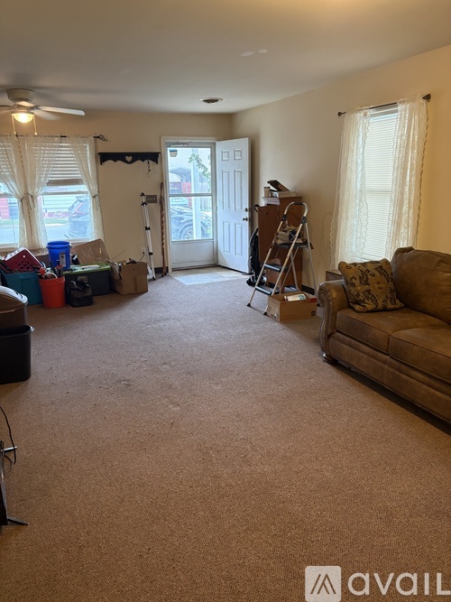 A room with a carpeted floor and a ladder in it.