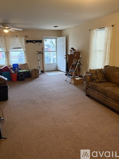 A room with a carpeted floor and a ladder in it.