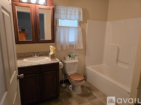 A bathroom with a toilet, sink, and bathtub.