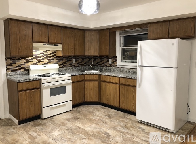 A kitchen with a white fridge, stove and oven.