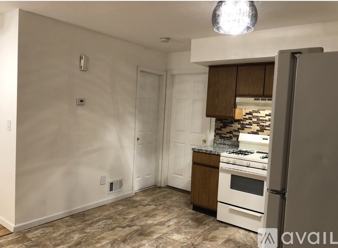 A kitchen with white appliances and brown cabinets.
