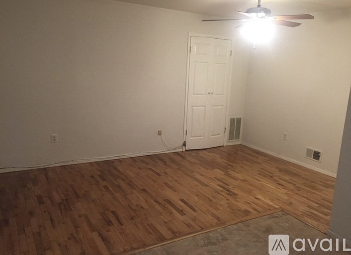 A room with wooden flooring and a ceiling fan.