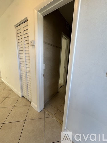 A white door with a window on the side is open.