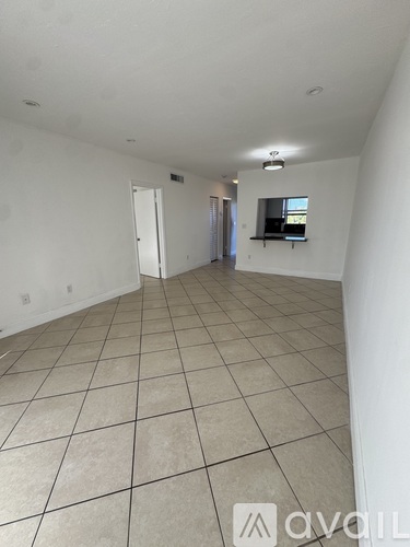 A spacious room with tiled flooring and a window.