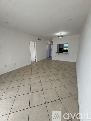 A spacious room with tiled flooring and a window.