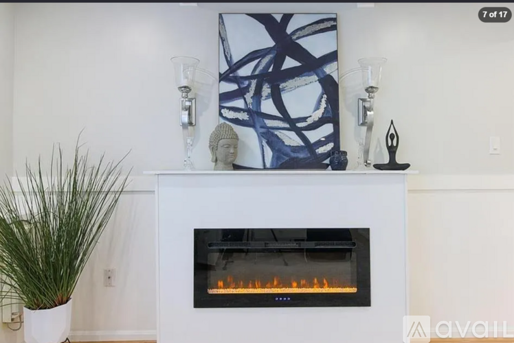 A modern fireplace with a blue abstract painting above it.