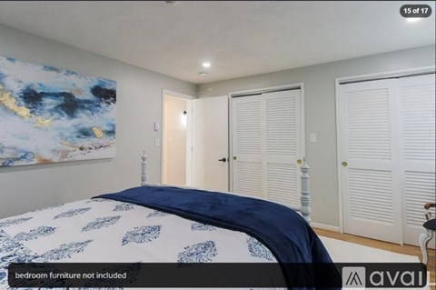 A bedroom with a large bed and a painting on the wall.