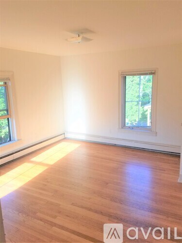 A room with wooden flooring and a window.