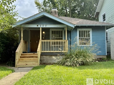 A small blue house with the number 6220 on the front door.