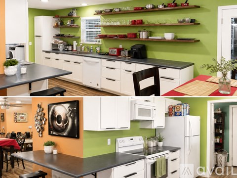 A kitchen with white cabinets and a green wall.