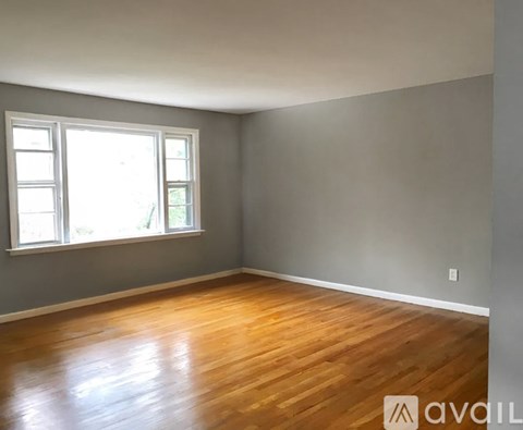 A room with wooden flooring and a window.