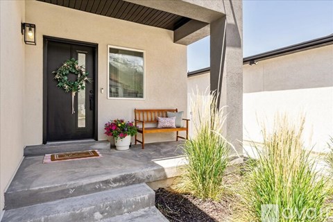A front porch with a bench and a wreath on the door.