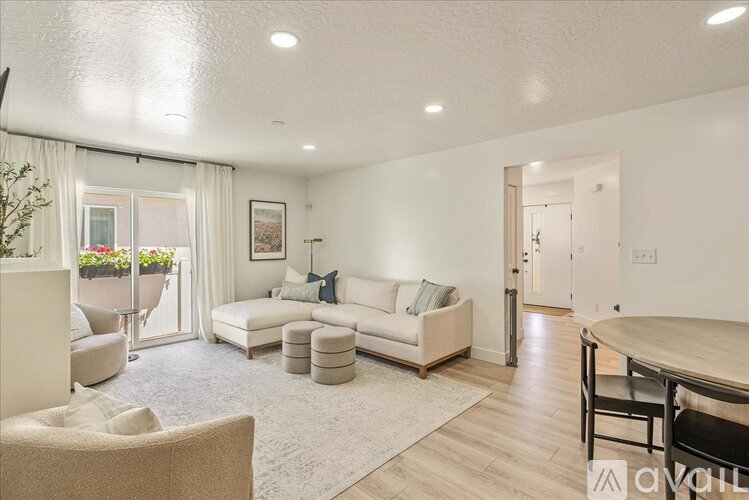 A living room with a white couch and a wooden table.