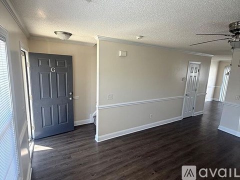 A room with a dark grey door and wooden flooring.