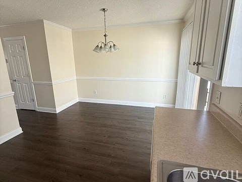 A kitchen with a wooden floor and white cabinets.