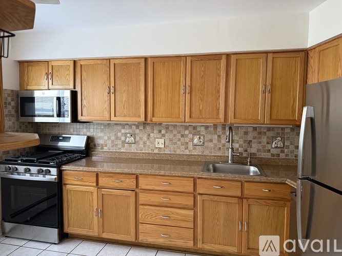 A kitchen with wooden cabinets and a black stove top.
