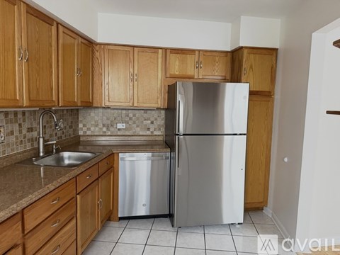 A kitchen with a stainless steel refrigerator, dishwasher, and sink.