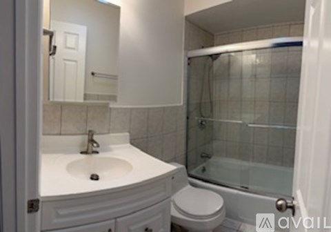 A white bathroom with a glass shower door.