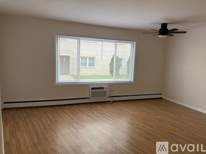 A room with a window and a fan on the ceiling.
