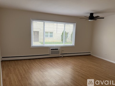A room with a window and a fan on the ceiling.