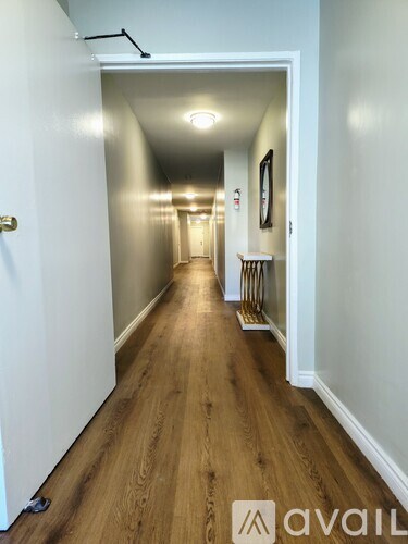 A long hallway with a bench and a picture on the wall.