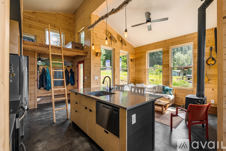A kitchen with wooden cabinets and a black fridge.