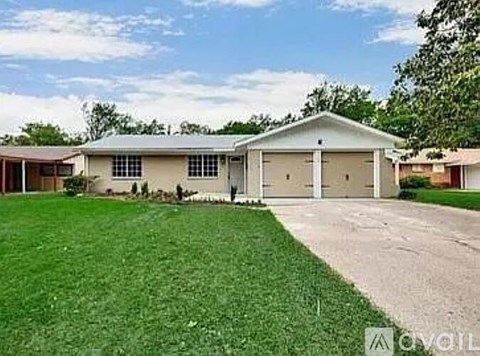 A two-story house with a garage and a driveway.