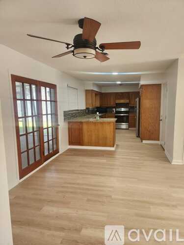 A room with a ceiling fan and wooden flooring.