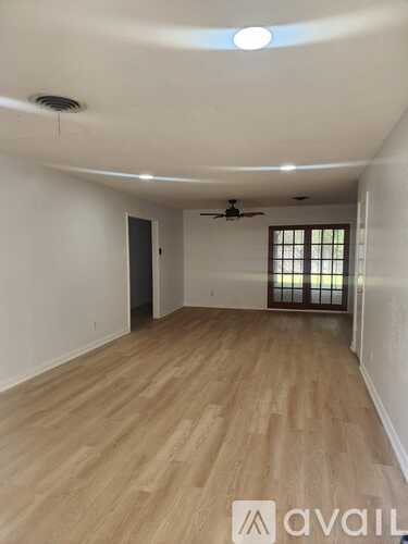 A room with wooden flooring and a ceiling fan.