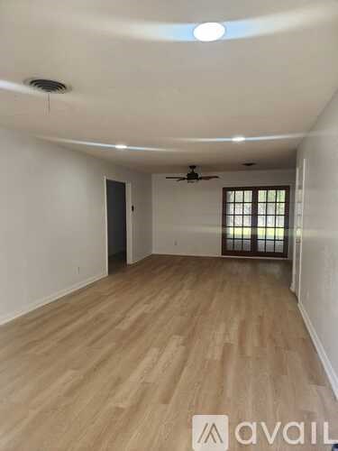 A room with wooden flooring and a ceiling fan.