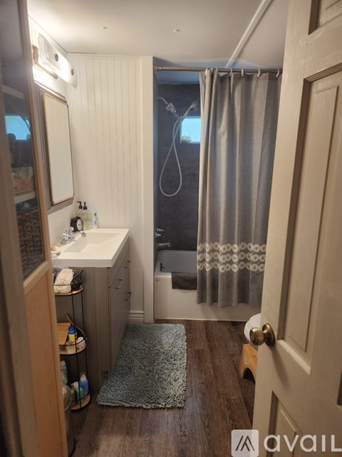 A bathroom with a sink, mirror, and shower.