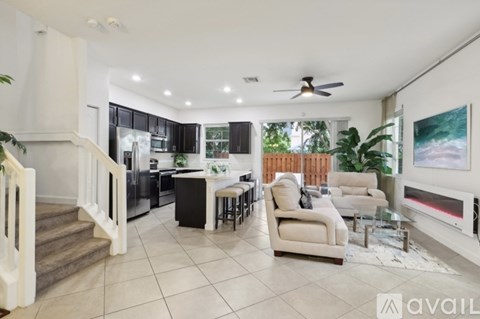 A spacious living room with a kitchen in the background.