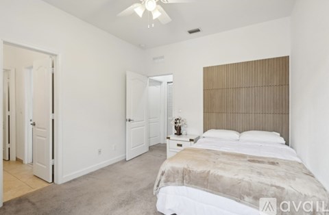A bedroom with a large bed and a ceiling fan.
