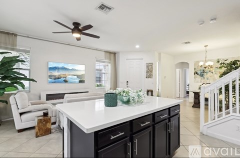 A modern kitchen with a large island and a ceiling fan.