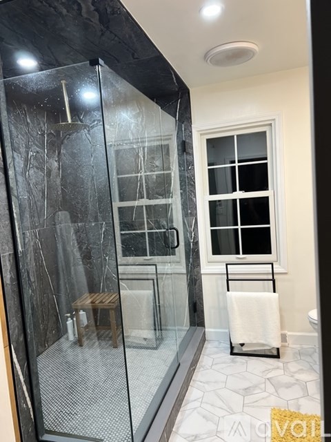 A bathroom with a walk-in shower and a towel rack.