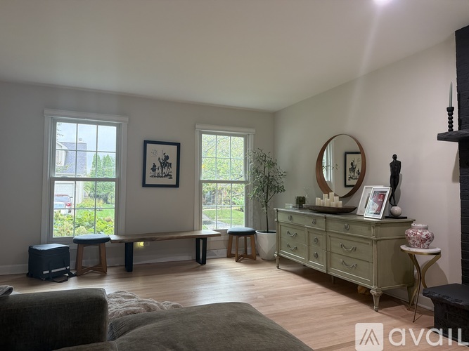 A living room with a grey couch and a wooden floor.