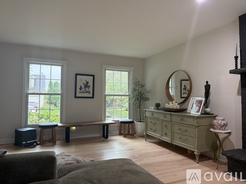 A living room with a grey couch and a wooden floor.