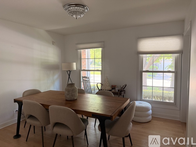 A dining room with a wooden table and chairs.