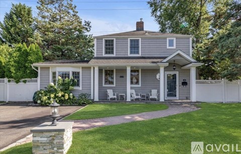 A house with a front yard and a white fence.