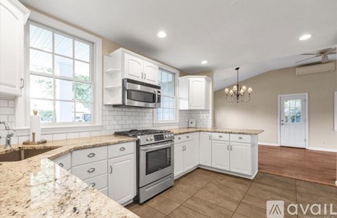 A kitchen with white cabinets and a granite countertop.