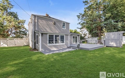 A house with a grey exterior and a white fence is for sale.