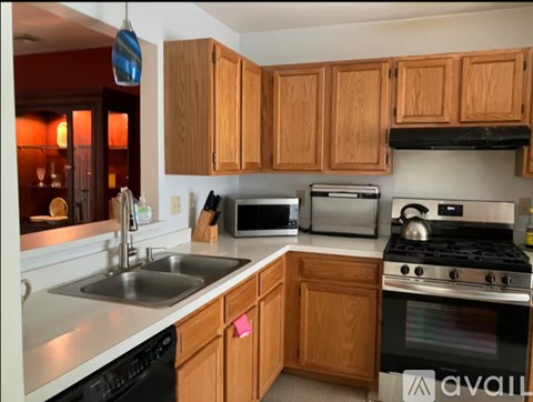 A kitchen with wooden cabinets and a black stove top oven.