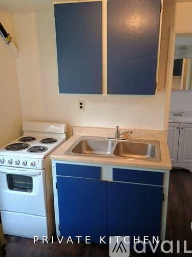 A kitchen with a stove, sink and cabinets.