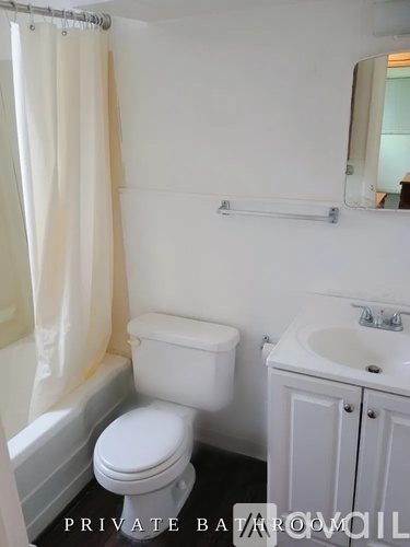 A white toilet and sink in a small bathroom.