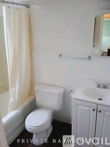 A white toilet and sink in a small bathroom.