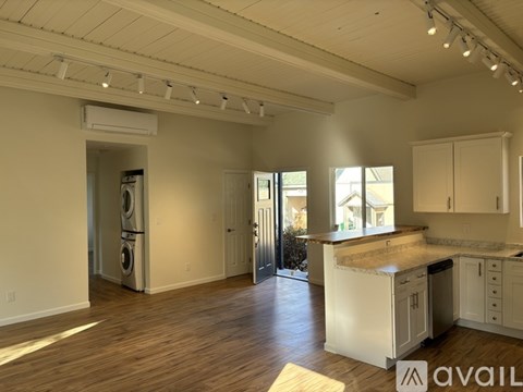 A spacious kitchen with white cabinets and a wooden island.